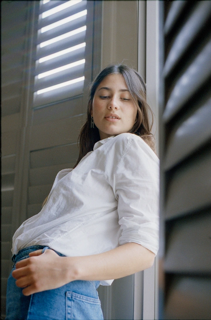 Portrait in a white shirt beside a window