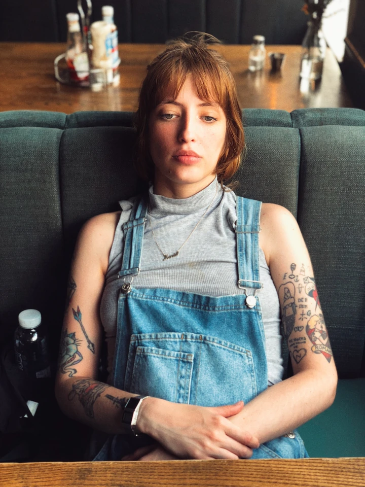 Portrait of a tattooed woman seated in an interior