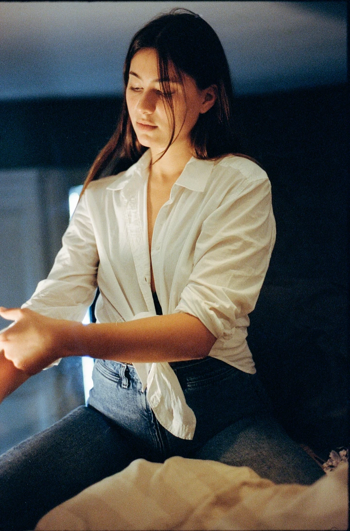 Seated portrait beside a window in a softly lit room